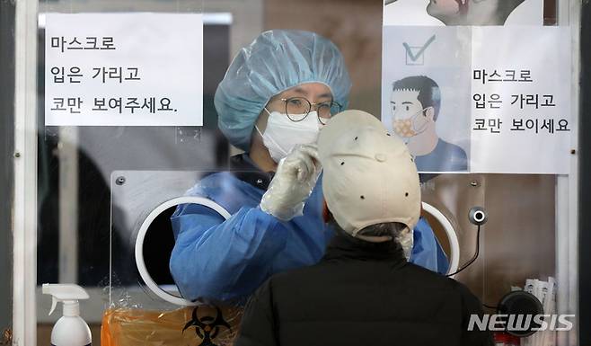 [서울=뉴시스] 고범준 기자 = 코로나19 신규 확진자가 3859명으로 집계된 17일 오전 서울 중구 서울역광장에 마련된 코로나19 중구임시선별검사소에서 의료진이 검체 채취를 하고 있다. 위중증 환자는 579명으로 54일만에 500명선으로 내려왔다. 2022.01.17. bjko@newsis.com