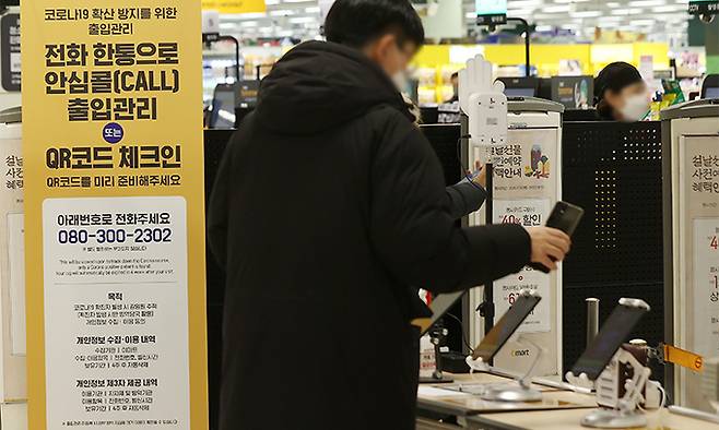 17일 서울의 한 대형마트 입구에서 시민들이 QR코드 체크를 하고 있다. 연합뉴스