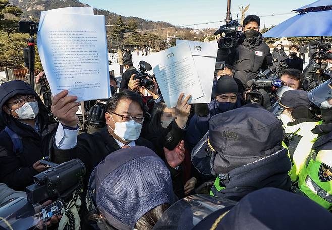 서해상에서 북한군 총격에 숨진 해양수산부 공무원의 부인 A씨(가운데)와 형 이래진 씨(왼쪽), 법률대리인 김기윤 변호사가 18일 오전 서울 종로구 청와대 분수대 앞에서 기자회견을 마친 뒤, 사건 발생 당시 문재인 대통령이 실종 해수부 공무원 아들에게 보낸 편지를 반환하기 위해 청와대 업무동으로 향하다 경찰에 저지되고 있다. /연합뉴스