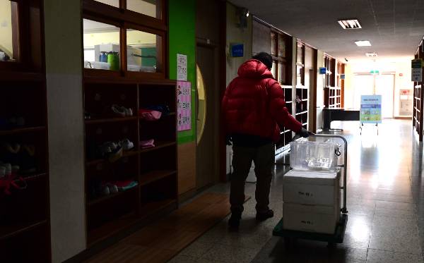 배달 알바에 나선 김 대표가 고양시의 한 초등학교 복도에서 아이들이 먹을 급식을 옮기고 있다.