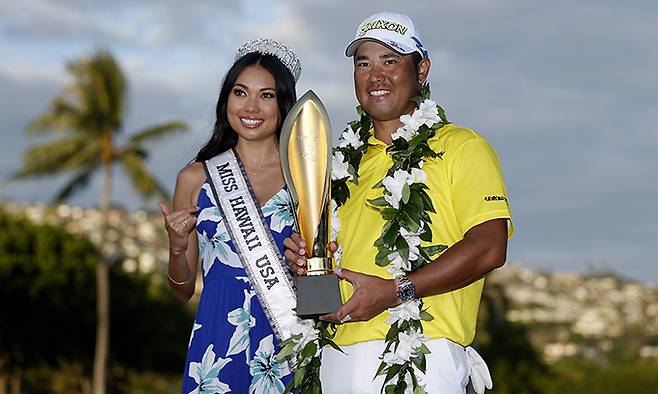 마쓰야마 히데키(오른쪽)가 17일 미국 하와이주 호놀룰루의 와이알레이 컨트리클럽에서 열린 PGA 투어 소니오픈에서 우승한 뒤 2021 미스 하와이 앨리슨 추와 함께 트로피를 들고 활짝 웃고 있다. 호놀룰루=AFP연합뉴스