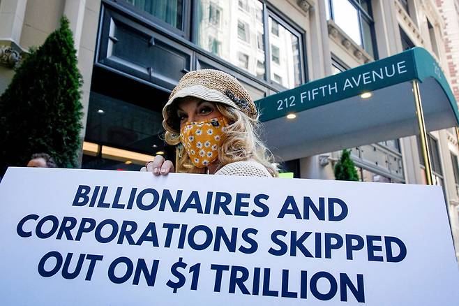 '애국적 백만장자' 회원이 미국 뉴욕의 아마존 사옥 앞에서 부유세 촉구 피켓을 들고 있다./로이터 연합뉴스