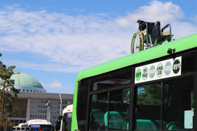 2021년 9월17일 국회의사당 앞에서 전장연 활동가들이 ‘버스 대폐차시 저상버스 도입 의무화’ 시위를 진행했다. 활동가들이 버스 위에 휠체어를 올렸다. 사진=장애인권 전문 언론 ‘비마이너’