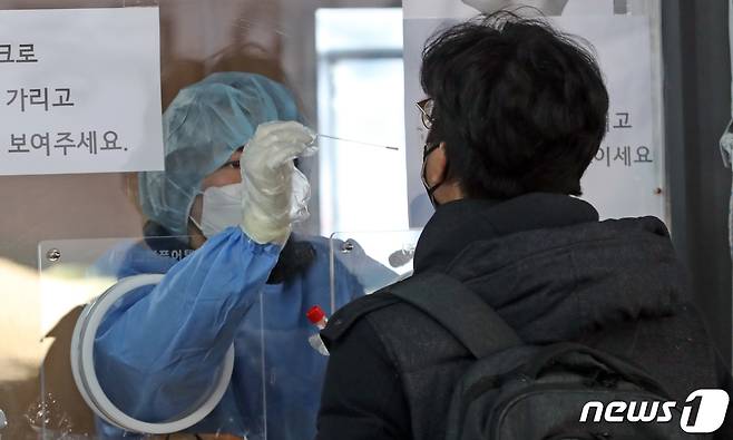 21일 오전 서울역 선별진료소에서 시민이 코로나19 검사를 받고 있다. /뉴스1