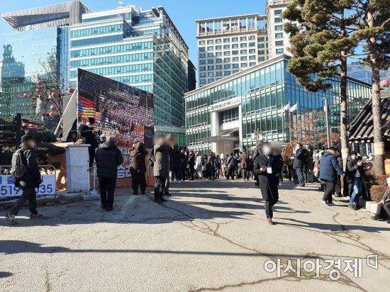 서울 종로 조계사 외부에 설치된 대형 스크린으로 신도들이 대회를 시청하고 있다. / 사진=임주형 기자 skepped@