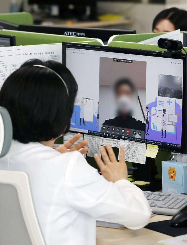 지난 19일 경기도 성남시의료원 재택치료 상황실에서 의료진이 ‘팍스로비드’를 복용하며 재택치료 중인 환자를 화상전화를 통해 진료하고 있다. 사진공동취재단