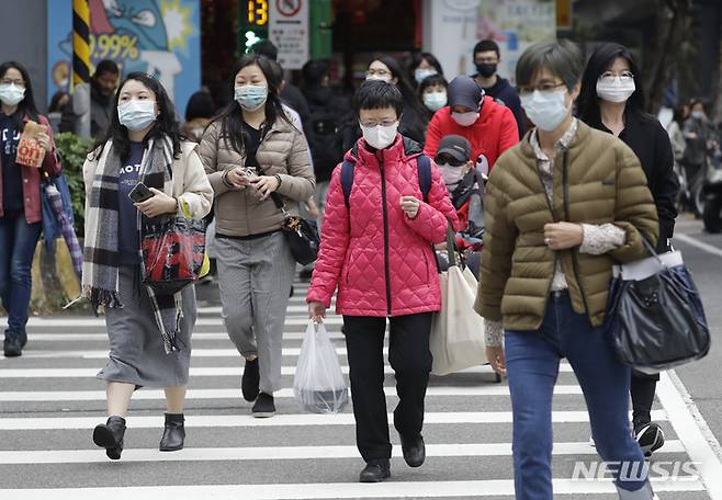 [타이베이=AP/뉴시스] 대만 수도 타이베이에서 7일 코로나19 예방을 위해 마스크를 착용한 시민들이 횡단보도를 건너고 있다. 2022.01.15