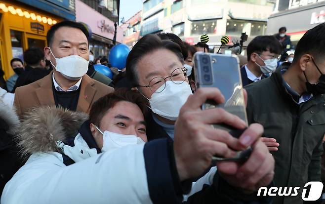 이재명 더불어민주당 대선 후보가 24일 오전 서울·경기 매타버스(매주 타는 민생 버스) '걸어서 민심 속으로'의 일환으로 경기 이천시 이천중앙로문화의거리를 찾아 지지자와 함께 '셀카'를 찍고 있다. 2022.1.24/뉴스1 © News1 국회사진취재단