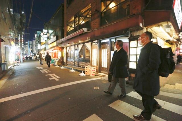 지난 21일 밤, 주점과 음식점이 늘어선 도쿄의 번화가에 사람들이 없어 한산하다. 도쿄의 신규 확진자는 22일 처음으로 1만 명을 돌파했다. 도쿄=AP 연합뉴스
