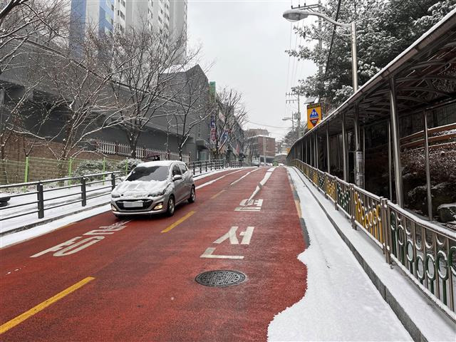 서울 성북구 정릉동 정수초등학교 앞 도로에 설치된 친환경 스마트 열선 때문에 경사가 높은 도로임에도 눈이 쌓이지 않아 차량이 안전하게 지나고 있다.성북구 제공