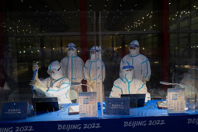 24일 중국 베이징 서우두 국제공항에서 전신 방호복을 입은 중국 요원들이 입국한 외국 참가단의 신원을 확인하고 있다./AP 연합뉴스