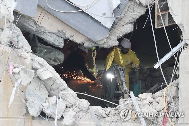 22층 잔해 제거에 투입된 굴삭기 (광주=연합뉴스) 김주성 기자 = 광주 서구 화정아이파크 붕괴 사고 2주째인 24일 오후 소형 굴삭기가 22층에 투입돼 잔해제거 작업을 하고 있다. 구조 당국은 이날부터  수색·구조작업을 24시간 지속 체계로 전환했다. 2022.1.24 utzza@yna.co.kr