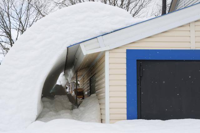 러시아 남서부 크라스노다르 준주 고르니 마을에 눈폭풍이 강타한 강누데 25일 한 건물 지붕에 쌓인 눈이 내려와 있다. 24일 고르니에 164cm의 눈이 내렸으며 22일부터 악천후로 크라스노다르 준주의 마을과 일대 지역에 비상사태가 선포됐다. 고르니=타스 연합뉴스
