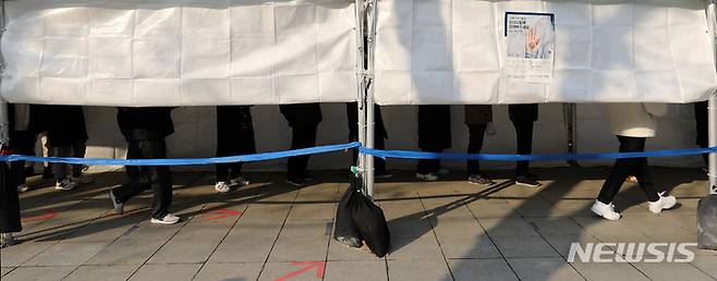 [서울=뉴시스] 백동현 기자 = 코로나19 신규 확진자가 13,012명으로 역대 최다를 기록한 26일 오후 서울 종로구 탑골공원 삼일문 임시선별검사소에서 시민들이 검사를 받기 위해 대기하고 있다. 2022.01.26. livertrent@newsis.com