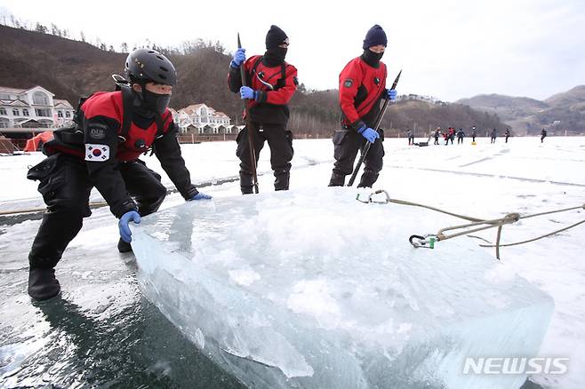 [홍천=뉴시스] 김경목 기자 = 24일 오후 소방청 중앙119구조본부 주최의 제37기 동계 수난구조 전문교육과정에 참가한 대원들이 강원도 홍천군 서면 홍천강 교육 장소에서 입수를 위해 잘라낸 얼음덩어리를 옮기고 있다. 이번 교육은 전국 시·도소방본부의 119구조대 대원들이 참가한 가운데 24~28일 닷새간 진행된다. 2022.01.24. photo31@newsis.com