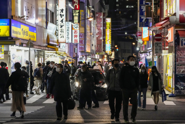 26일 일본 도쿄에서 코로나바이러스 확산을 막기 위해 마스크를 쓴 사람들이 횡단보도를 걷고 있다. 감염자가 증가함에 따라 도쿄와 오사카, 교토 등 대도시 지역을 포함한 일본 대부분 지역의 술집과 음식점 영업시간이 단축된다. 또 대규모 공공행사에 대한 규제가 강화된다./AP연합뉴스