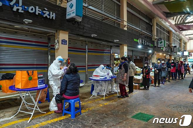 전남 목포시에서 새해 들어 코로나19 확진자가 급증하고 있는 가운데 26일 시장에 마련된 선별검사소에서 상인들이 검체 채취에 응하고 있다.(목포시 제공)2022.1.26/뉴스1 © News1