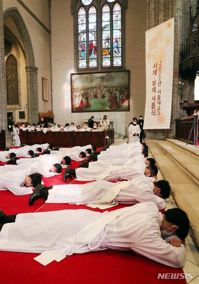 [서울=뉴시스] 사진공동취재단 = 28일 서울 중구 명동성당에서 열린 천주교 서울대교구 사제 서품식에서 사제 수품 후보자들이 세상에 죽고 하느님께 봉사하겠다는 것을 드러내기 위해 부복하고 있다. 2022.01.28. photo@newsis.com