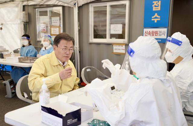 문재인 대통령이 설 연휴인 30일 경부고속도로 안성휴게소(서울방향)에 설치된 코로나19 임시선별검사소를 방문, 신속항원검사 키트를 직접 사용해보고 있다. 안성=왕태석 선임기자