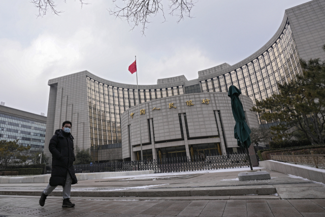 마스크를 쓴 한 남성이 20일 베이징의 중국 인민은행을 걷고 있다. 중국 중앙은행인 인민은행은 올해 사실상의 기준금리인 대출우대금리(LPR)를 두 달 연속 인하했으나 중국 경기는 좀처럼 회복되지 않고 있다. /AP연합