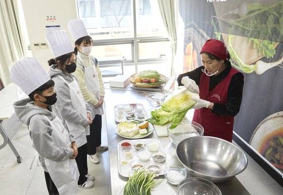 배추 절이는 법을 설명하는 곽 명인. 배춧잎 사이사이 굵은 소금을 뿌려 배추 숨이 죽도록 둔다.