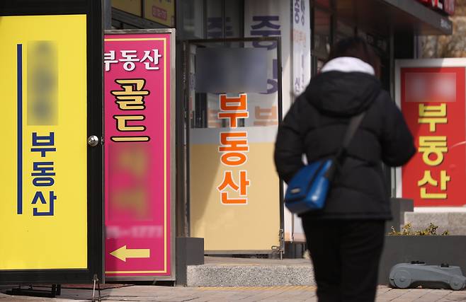지난 1월 23일 서울 시내 한 부동산 중개업소 앞을 시민이 걸어가고 있다. [연합]