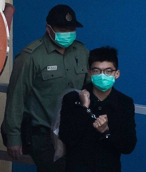 지난해 12월 18일 조슈아 웡이 수갑을 찬 채로 구치소를 나오는 모습. /AFP