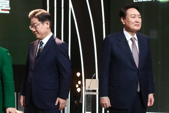 3일 오후 서울 여의도 KBS 공개홀에서 열린 2022 대선후보 토론에서 이재명 더불어민주당 대선 후보가 기념촬영을 마친 뒤 자리로 돌아가고 있다. 오른쪽은 윤석열 국민의힘 대선 후보. 사진=뉴스1