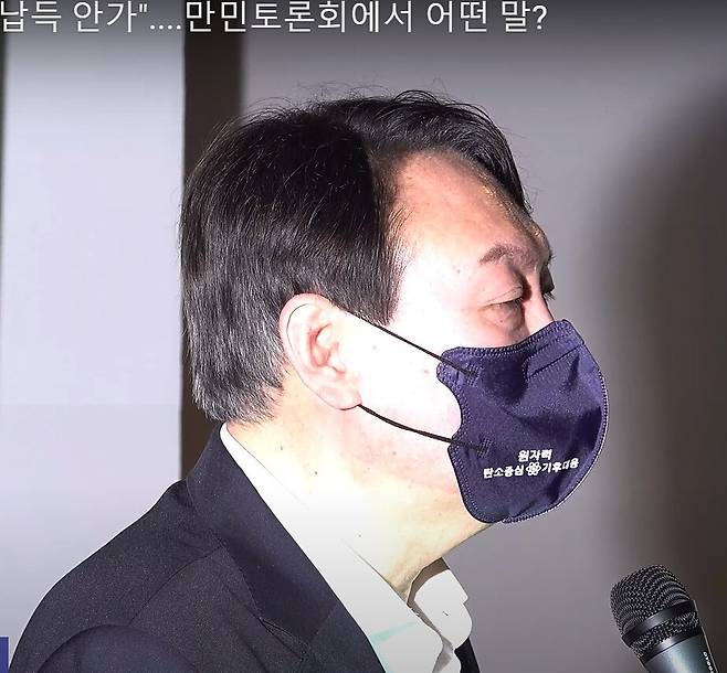 윤석열 전 검찰총장이 2021년 7월 6일 오후 대전 유성구에서 열린 ‘문재인 정권 탈원전 4년의 역설’ 만민토론회에 참석해 발언하고 있다. 윤 전 총장이 쓴 마스크에 적힌 ‘탄소중심’ 오타가 화제가 됐다. 유튜브 새마을방송 갈무리