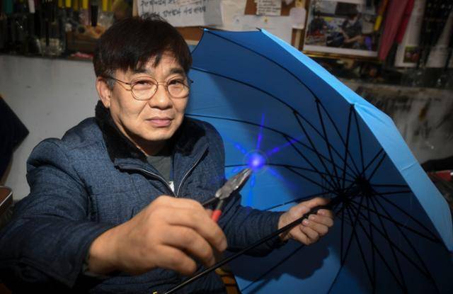 지난달 25일 서울 종로구 우산 판매·수리점 '연흥사' 사장 김석환씨가 우산 고치는 방법을 시연하고 있다. 그는 40년간 이 자리에서 우산을 고쳐 왔다. 못 고치는 우산이 없는 '우산 박사'다. 한지은 인턴기자