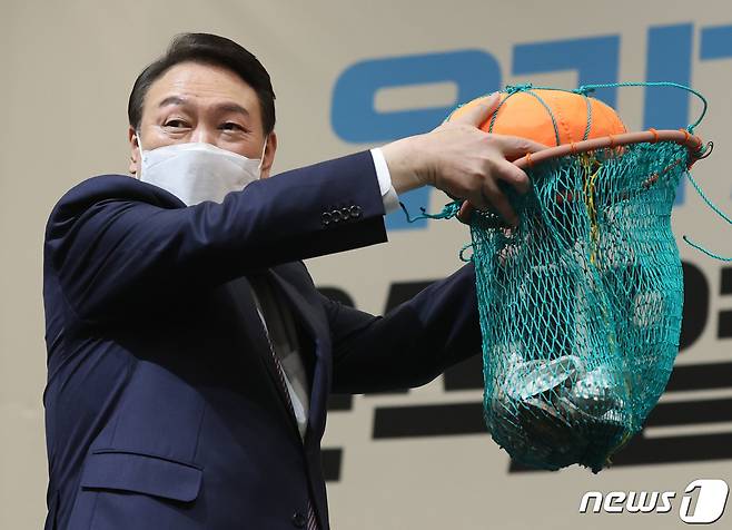 윤석열 국민의힘 대선 후보가 5일 오후 제주 퍼시픽호텔에서 열린 '제주 선거대책위원회 필승결의대회'에서 최연소 해녀인 정희선, 마희주 씨에게 해녀들이 물질할 때 쓰는 테왁을 전달받고 있다. 2022.2.5/뉴스1 © News1 구윤성 기자