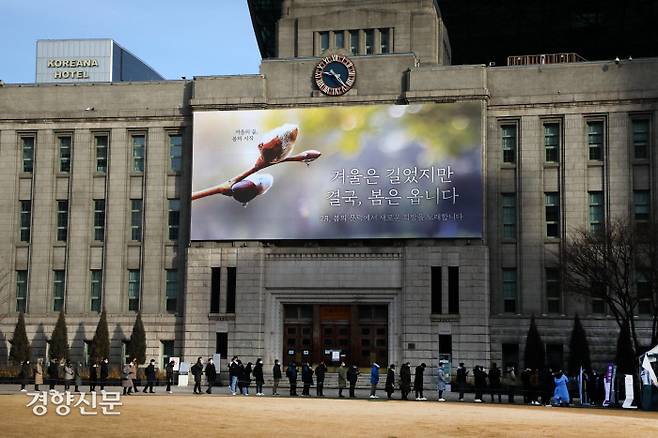 코로나19 오미크론 변이 대유행으로 신규확진자가 3만5824명을 기록한 7일 서울시청광장 임시선별검사소에 많은 시민들이 ‘겨울은 길었지만’ 걸게그림 밑에서 검사를 기다리고 있다./박민규 선임기자