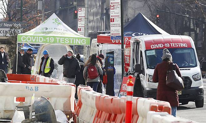지난 8일(현지시간) 미국 뉴욕의 코로나19 바이러스 선별진료소 앞을 시민들이 지나가고 있다. UPI연합뉴스