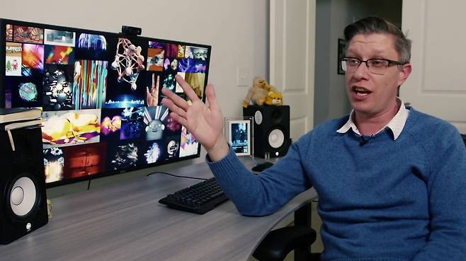 비플이라는 이름으로 활동중인 미국의 디지털 예술가 마이크 윈켈만이 화면에 뜬 자신의 디지털 미술 작품에 대해 설명하고 있다./크리스티
