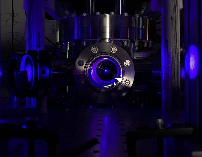 미국 위스콘신매디슨대 연구팀이 개발한 스트론튬 광격자시계의 모습이다. 광격자시계의 작동을 위해서는 먼저 원자를 절대온도 0도에 가깝게 냉각해야 한다. 원자를 냉각하면 사진과 같이 진공기 안에 파란색 공 같은 형태가 관찰된다. 시몬 콜코위츠 제공