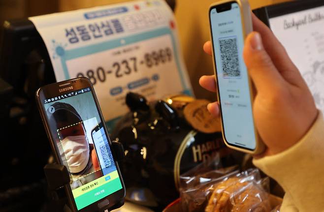 13일 서울 시내 카페에서 방문 고객이 전자출입명부 QR코드를 태그하는 모습. (사진=연합뉴스)