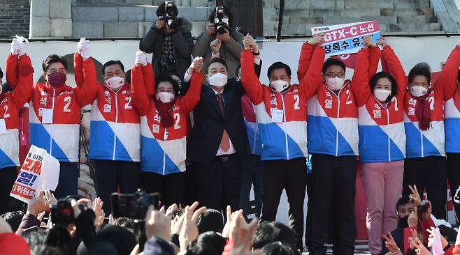 국민의힘 윤석열 대선 후보가 24일 오후 경기도 수원시 팔달문 앞에서 열린 수원 집중유세에서 당 관계자들과 손을 맞잡아 들어올리고 있다. 국회사진기자단