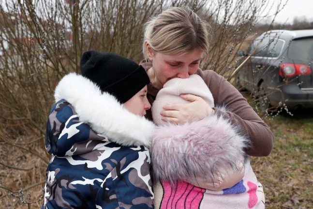 - 우크라이나인 안나 세먹(33)이 낯선 아주머니와 함께 우크라이나 국경을 넘은 아이들을 헝가리 쪽 초소 근처에서 만나 품에 안고 있다. 로이터통신 연합뉴스