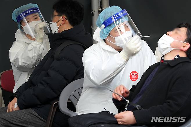 [서울=뉴시스] 지난 25일 오전 서울 중구 서울역광장 임시선별검사소에서 의료진이 검체를 채취하고 있다. 2022.02.25. livertrent@newsis.com