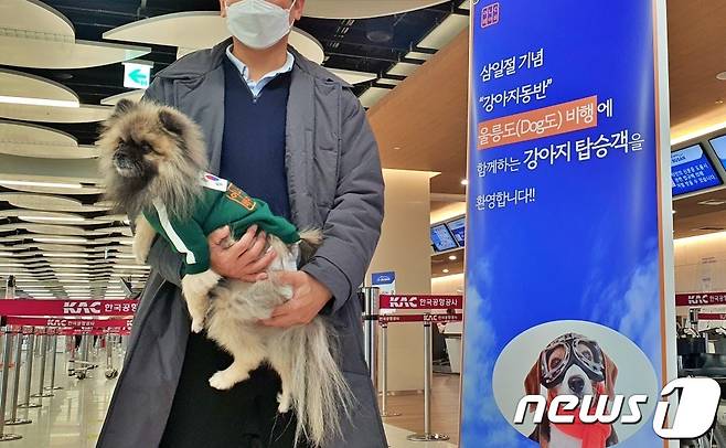 어나더베이비는 1일 '반려견과 함께하는 3.1절 기념 울릉도(DOG도) 비행' 행사를 주최했다. 한 탑승객이 기저귀를 찬 강아지와 기념촬영을 하고 있다. © 뉴스1 최서윤 기자