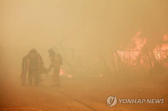 가스 충전소로 다가오는 산불 (울진=연합뉴스) 김현태 기자 = 5일 오후 경북 울진군 연지리의 한 LPG 가스 충전소 인근으로 산불이 번지고 있다. 2022.3.5 mtkht@yna.co.kr