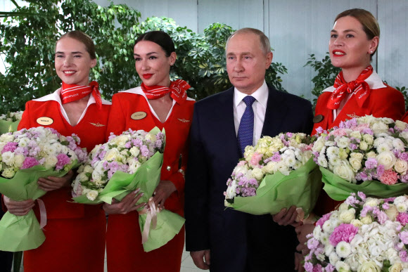 블라디미르 푸틴 러시아 대통령이 5일(현지시간) 국제 여성의 날을 앞두고 모스크바 근교에 있는 국영항공사 아에로플로트 항공학교를 방문해 여승무원들과 기념사진을 찍고 있다.로이터 연합뉴스