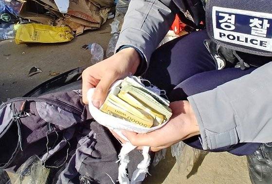 지난 5일 충남 부여경찰서 규암파출소 직원들이 쓰레기더미 속에서 할머니가 천에 싸아 보관하던 현금을 발견했다. [사진 충남경찰청]