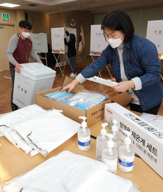 (수원=뉴스1) 김영운 기자 = 제20대 대통령선거를 하루 앞둔 8일 오후 경기 수원 장안구 조원1동 행정복지센터에 마련된 조원1동 제1투표소에서 관계자들이 투표소 설치를 하고 있다. 2022.3.8/뉴스1