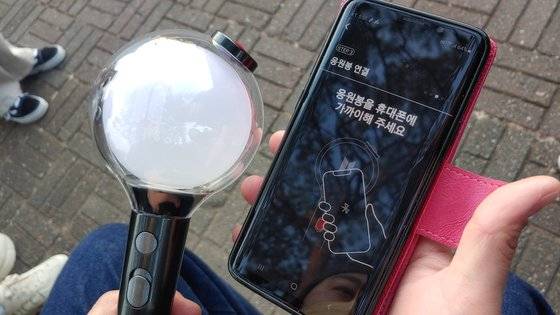 BTS 공식 굿즈는 경기장 앞에서 팔지 않고, 잠실 롯데몰에 마련된 스토어에서만 판매했다. 공식 조명은 핸드폰 앱과 연동해, 공연장 좌석 위치에 따라 노래에 맞춰 변할 수 있도록 했다. 사진은 한 팬이 공식 조명 응원봉을 핸드폰 앱과 연결하는 장면. 김정연 기자