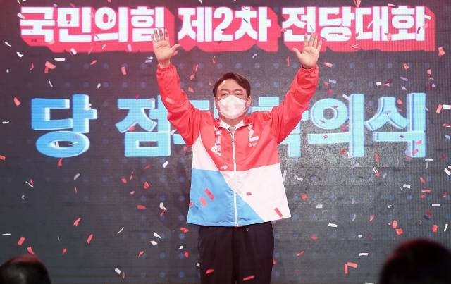 윤석열 당선인이 2021년 11월 5일 서울 용산구 백범기념관에서 열린 전당대회에서 국민의힘 대선 후보로 선출된 뒤 두 손을 들어보이고 있다. 국회사진기자단