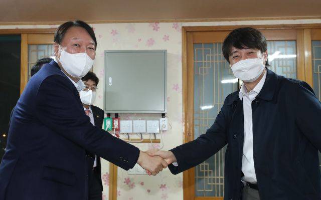 윤석열 당선인이 2021년 12월 3일 울산 울주군의 한 식당에서 이준석 국민의힘 대표와의 만찬회동에 앞서 악수를 나누고 있다. 연합뉴스