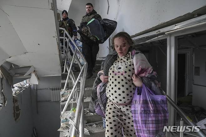 [마리우폴=AP/뉴시스] 9일(현지시간) 우크라이나 마리우폴에서 산부인과 병원이 러시아군의 포격을 받아 부상한 임신부가 계단을 걸어 피신하고 있다. 볼로디미르 젤렌스키 우크라이나 대통령은 "아이들과 사람들이 병원 잔해에 깔려 있다"라며 이번 공격을 "잔혹 행위"라고 비난했다. 2022.03.10.