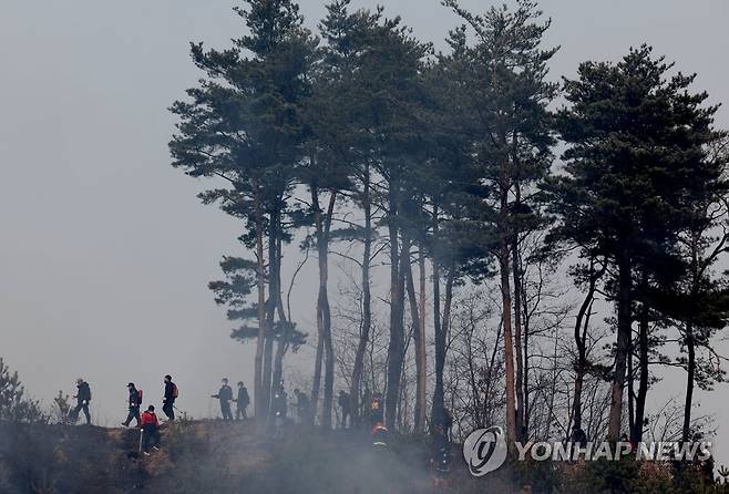 연기 속에서 (울진=연합뉴스) 류영석 기자 = 울진·삼척산불이 계속되는 8일 경북 울진군 울진읍 신림리 일대에서 산불진화대가 이동하고 있다. 2022.3.8 ondol@yna.co.kr