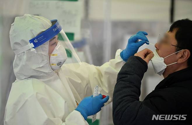[대구=뉴시스] 이무열 기자 = 코로나19 신규 확진자가 30만9790명으로 집계된 14일 오전 대구 달서구 옛 두류정수장 임시선별검사소에서 의료진이 검체를 채취하고 있다. 2022.03.14. lmy@newsis.com